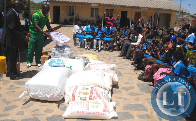 GREEN Eagles Football Club manager Captain Kennedy Nkanga (right) presents a donation of assorted foodstuffs and groceries on behalf of the team to Saint Mulumba School of the disabled Children head teacher Jesart Ngulube in Choma