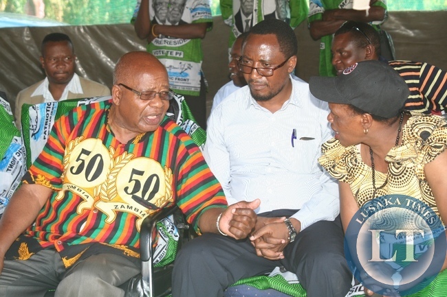 Southern Province Minister Daniel Munkombwe (l) confers with PF Deputy Secretary General Bridget Atanga (r) as Western Province Minister Richwell Siamunene (c) looks on during a PF Rally meeting at Blue Gums in Mongu District of Western Province