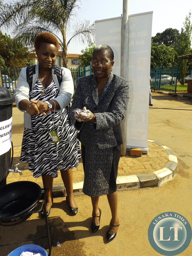 Lusaka High Court Judge Anesi Bobo-Banda demonstrates the washing of hands during the commemoration of the global hands washing day at Lusaka magistrate court