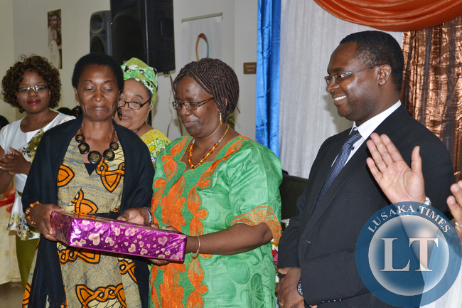 Gender in Development Department Director in the Ministry of Gender and Child Development, Bupe Kaonga (centre) presents the Most Improved Business Entrepreneur of the Year award to Naziya Investments proprietor Winnie Wachivula (left) as Zambia Breweries Corporate Affairs Director Luke Njovu looks on at the Month of the Woman Entrepreneur awards dinner at Government complex in Lusaka recently.