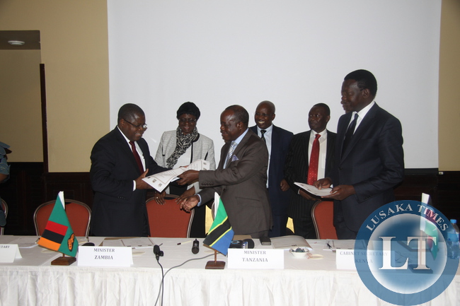 Mines, Energy and Water Development minister Christopher Yaluma (left) exchanges documents with Tanzanian minister of Energy and Minerals, Sospeter Muhango (middle) and looking on is Kenyan Cabinet Secretary ministry of Energy and Petroleum, Davis Chirchir (far right). This was after the signing ceremony of the framework agreement in Dar Es Salaam to kick start the long awaited Zambia-Tanzania-Kenya (ZTK) power interconnector project.