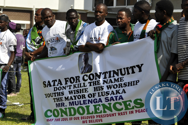 PF supporters of Mulenga Sata campaigning for Mulenga's PF party presidency with a placard before president Sata's body arrived