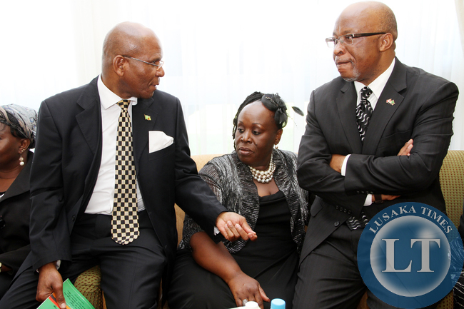 MMD president Nevers Mumba (r) listens to Commerce minister Bob Sichinga shortly before President Sata's Body arrived at Kenneth Kaunda International Airport from London on November 1,2014 -Picture by THOMAS NSAMA