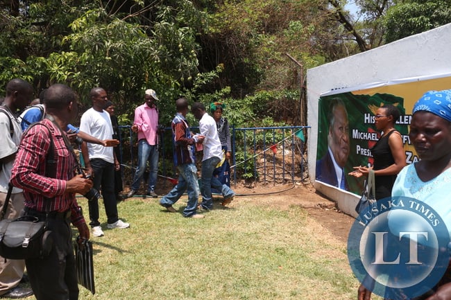 Some mourners posing next to banners displaying the late President Sata at the Mulungushi conference centre