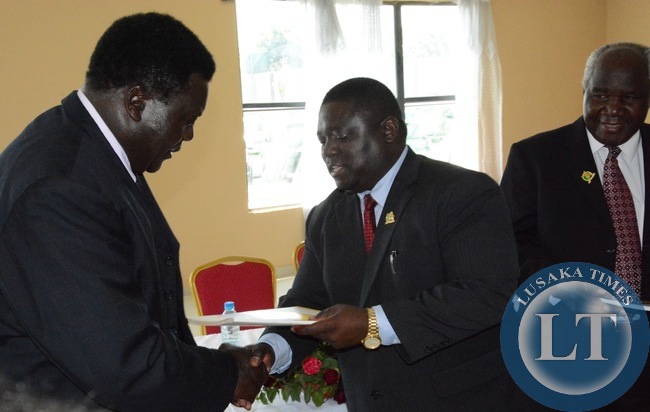Transport and Communication Minister Yafya Mukanga handover Road Maintenance Strategy 2014-2024 to RDA board chairman Willie whilst his Deputy Minister Panji Kaunda during the launch of Road Maintenance Strategy 2015-2024 book