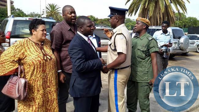 Police officers attempt to keep Bowman Lusambo from Muhabi Lungu (not in picture) at the Supreme Court in Lusaka