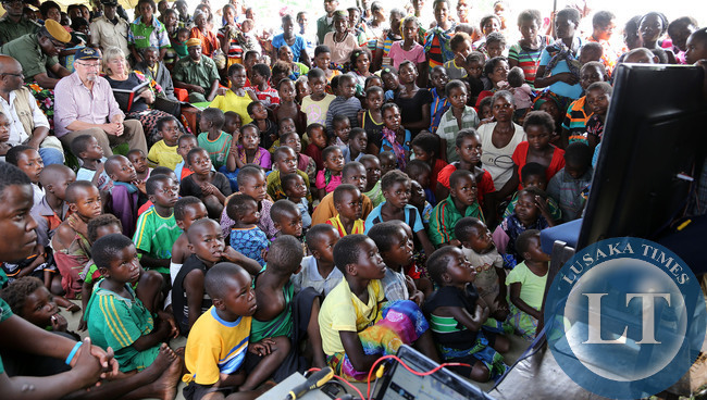 Dr Guy Scott with Bwangweulu Swamps Children at Kasenga watching Batwa pepole Film 5107 Dr Guy Scott with Madam Charotte Watching a Movie on Batwa People at Kasenga School in Samfya District in Luapula after he inspected Government Projects.Picture by Eddie Mwanaleza/ Statehouse 14-01-2015.