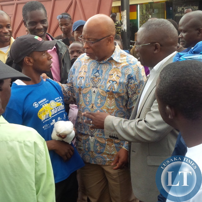 Dr Mumba chats with marketeers at Chilenje Market flanked by supporters and MMD Acting National Secretary Mwansa Mbulakulima