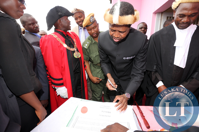 President Edgar Lungu signs a Roll at Honourary Freeman of the Chipata Municipality at Civic Centre, Looking is town Clerk Davies Musenge and mayor Mr Jealous Phiri on Friday 27-02-2015. PICTURE BY EDDIE MWANALEZA/STATEHOUSE.