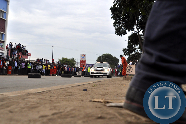 An identified spectator paves way for an on-coming motor rally car