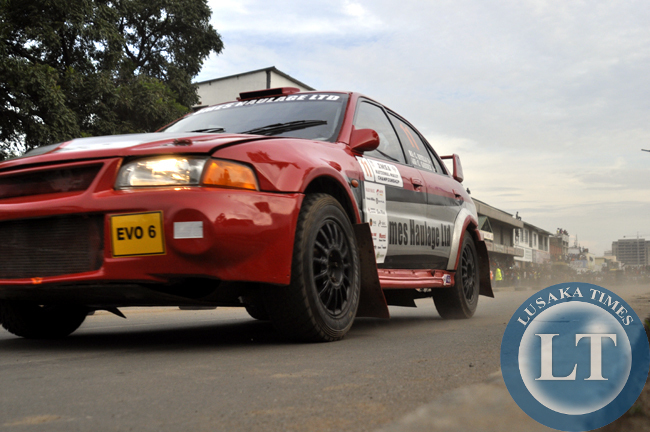 Spectators cheering a rally driver cruising along freedom Way during the ZMSA national motor rally championship