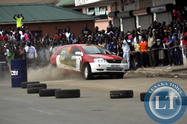 Spectators cheering a rally driver cruising along freedom Way.