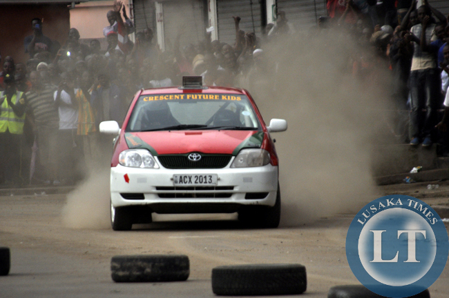 Spectators cheering a rally driver cruising along freedom Way