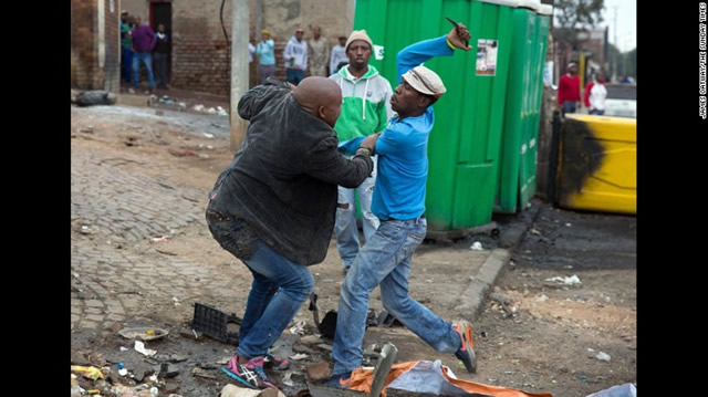 Mozambican Emmanuel Sithole was walking down a street in johannesburgs Alexandra township when 4 men surrounded him on Saturday 18th April.Sithole pleaded for mercy but it was too late.The attackers bludgeoned him with a wrench and stabbed him with knives ,killing him in broad daylight.Photographer James Oatway was nearby and captured it all on camera