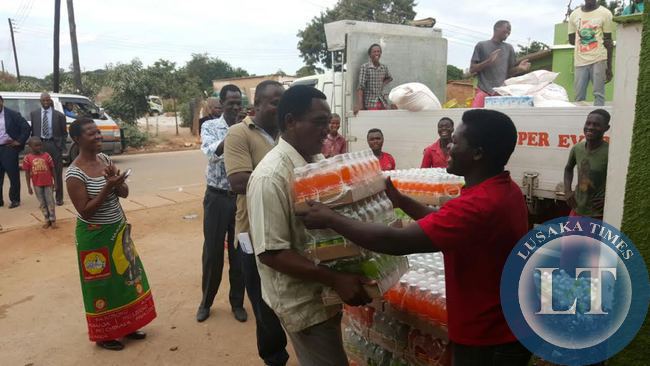 UPND President Hakainde Hichilema helps offload soft drinks in Linda compound