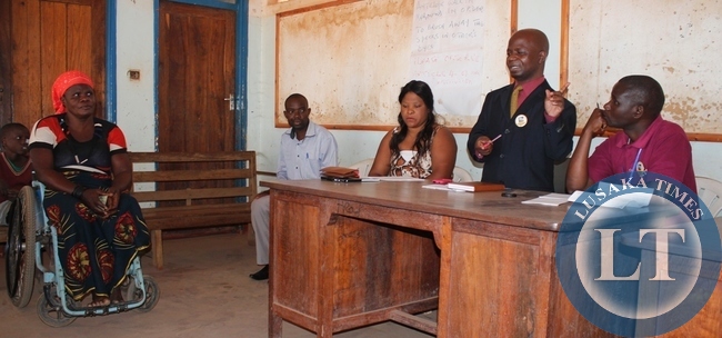 Acting Mbala District Administrative Officer, Frederick Chilambwe addressing the beneficiaries of community payphone empowerment provided by ZICTA at Mbala Community Hall