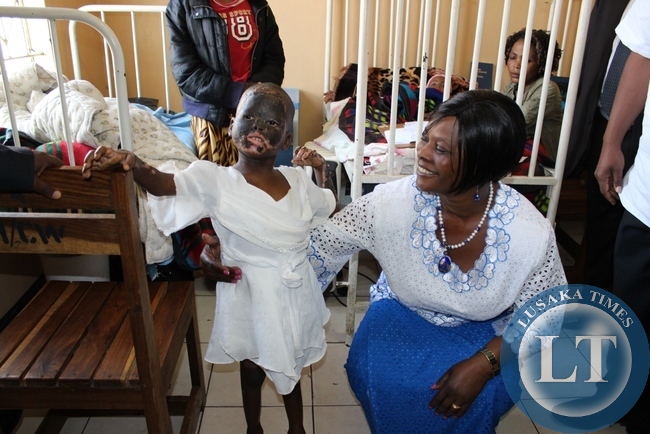 First Lady Esther Lungu visits a child who has been burnt at Lewanika General Hospital during the commissioning of a relatives’ shelter constructed with the support of the Ministers’ Wives Club in Mongu