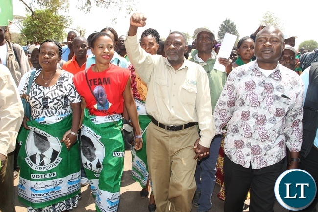 PF candidate George Mwamba flash the party symbol whilst Tasila Lungu (2nl), Hon. Ester Banda (l) and Father Bwalya (r) presents his credentials for nomination to presiding officer Christopher Simusokwe during the filling in of nomination for Lubanseshi constituency Luwingu District Council
