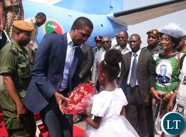 President Edgar Lungu receives a bouquet of flowers from a nine year old girl Sante Mwanza upon arrival at Solwezi airport as provincial Patriotic Front (PF) women’ chairlady Martha Mpila ( r) looks on in Solwezi