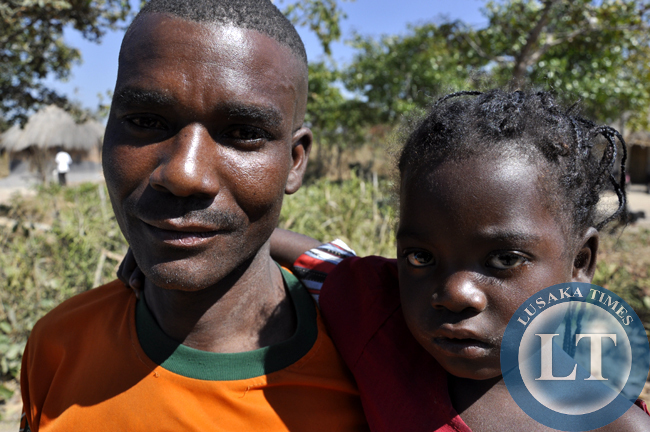 An unideitfied father with his daughter at captured in chief Mulala's area in Luwingu. There are many cases of child marriages and school dro-outs in the area