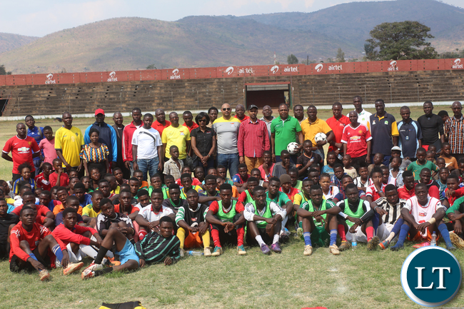 Minister of Youth and Sport Vincent Mwale in the middle wearing a black cap and a red shirt, on his left Airtel Public Relation officer Lisa Mulozi, FAZ Committer member Lee Kawanu and immediate to his right FAZ President Kalusha Bwalya posing with the youth of Eastern Province that turned out during the Airtel Talents Search at Eastern Province Chipata David Kaunda stadium on Saturday, Septembet 26th .