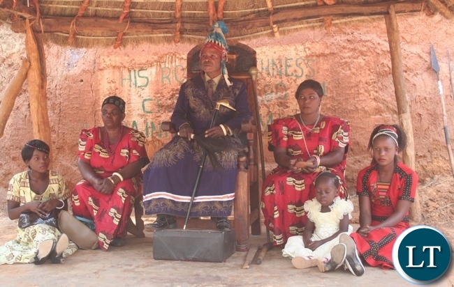 Chief Matebo with his wives, Cydah (l) and Phillies (r ) follow the proceedings of the Kuvuluka Kishakulu tradition ceremony at the royal grounds in Solwezi