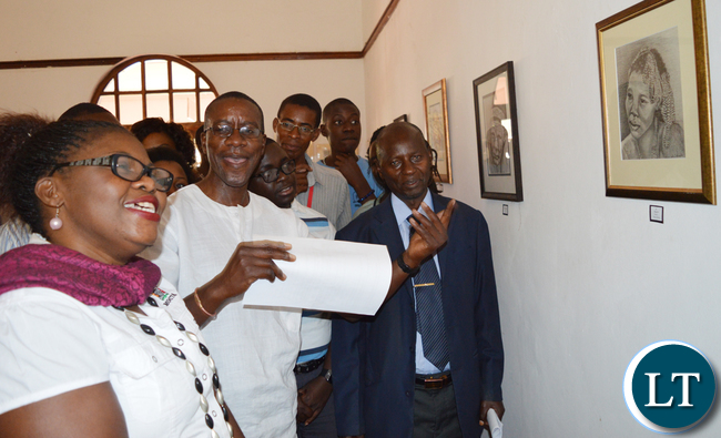 Mazabuka based artist Alec Lishandu (middle) shows Choma district administrative officer Vincent Sikanyela (in a jacket) and Choma Museum director Bevine Sangulube (left) some of his artistic works during opening of an art exhibition at the museum