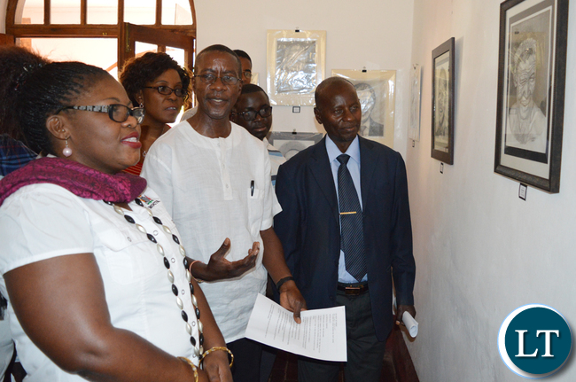 Mazabuka based artist Alec Lishandu (middle) shows Choma district administrative officer Vincent Sikanyela (in a jacket) and Choma Museum director Bevine Sangulube (left) some of his artistic works during opening of an art exhibition at the museum