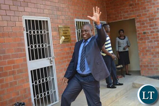 Jailed former Livingstone Mayor and Lizuma Ward Councillor, Aggrey Njekwa, waves to his sympathisers near the holding cells for Livingstone Courts