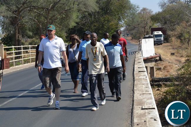 An 86-year old Livingstone man, Kizito Nawa, walked for a distance of 22 kilometres (km) from the central business district to Victoria Falls to raise money for charity. Above, Mr Nawa (middle) being helped to do a fundraising walk by other symphasithers in Livingstone