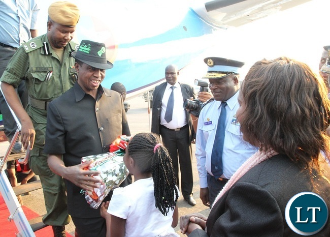 PRESIDENT Edgar Lungu receives a bouquet of flowers from a 10 year old girl at Solwezi Airport