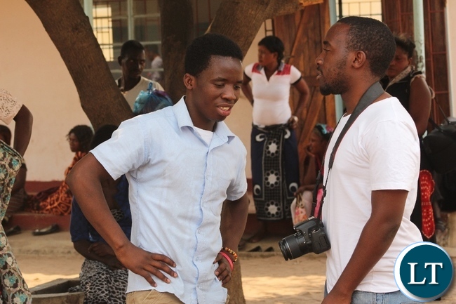 Abraham Chilemu (l) talking to MUVI TV Journalist Lloyd Kapusa (r) after a court trial in Mongu in which he was a victim of sodomy to Hatch Bril (not in picture) yesterday. Abraham is 19 years old, a taxi driver who was deceived by Hatch into sodomy.