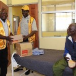Lions Club of Mongu President Lion Percy Walusiku (c) and his 3rd President President Lion KapaluMuswala (l) distributing food stuffs during the donation to eye patients to observe the World sight Week ahead of the World Sight Day