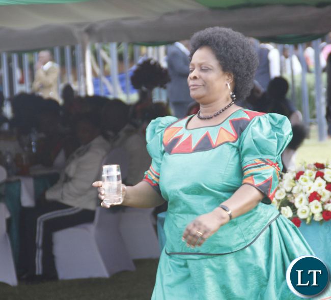 First Lady Edgar Lungu taking a glass of water to President Edgar Lungu to propose a toast.
