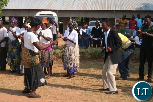 Mutanda secondary school deputy headteacher Isaac Lijimu (r ) joins the Mukumbi Ibaloli culture group in dancing the hunters dance locally known as Katembo during the official handover of a modern 1 x 3 science laboratory constructed by Lumwana mining firm at total cost of K1million