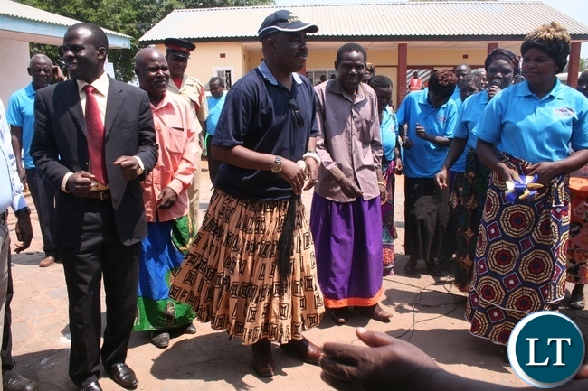 Solwezi acting district commissioner Chipawa Chipawa (l) with chief Mumena (in a cap) dancing to the Mukumbi Ibaloli culture song on Thursday during the official handover of Mukamena Multipurpose cooperative centre which has been constructed by Lumwana mining company at Mutanda at a total cost of K240,000.