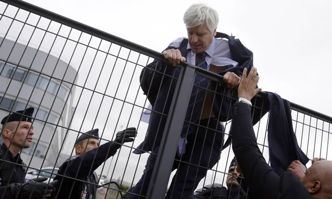 Pierre Plissonnier, vice-president of Air France at Orly airport in Paris, is helped by police to escape the protesters. Photograph: Kenzo Tribouillard/AFP/Getty Images