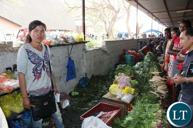 A Chinese Woman Selling Vegetables in a Lusaka Market