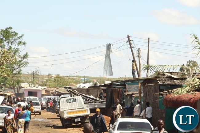 Baulini Residents looking at the roof on the ZESCO after it was blown off due to heavy rains in Baulini
