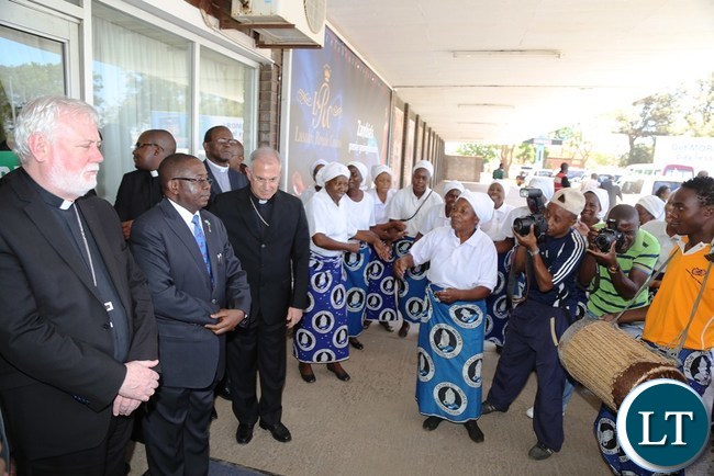 His excellency Mgrs.Poul Richard Gallgher (L) flanked by Foreign Affairs Deputy Minister Reyford Mbulu (2nl) being welcomed at Kenneth Kaunda International Airport by Ridgment Parish chair yesterday
