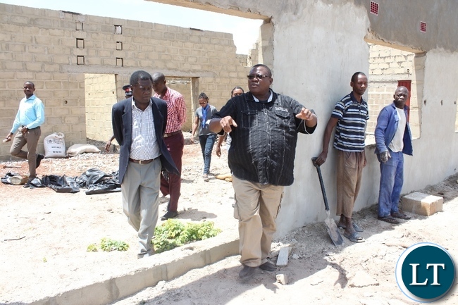 Adastra Fruit Juice Processing proprietor Noyoo Ikanuke (c) with Mongu District Commissioner Susiku Kamona (l) at the site of a mango processing plant during the inspection of work progress on projects funded by Citizens Economic Empowerment Commission (CEEC) in Mongu