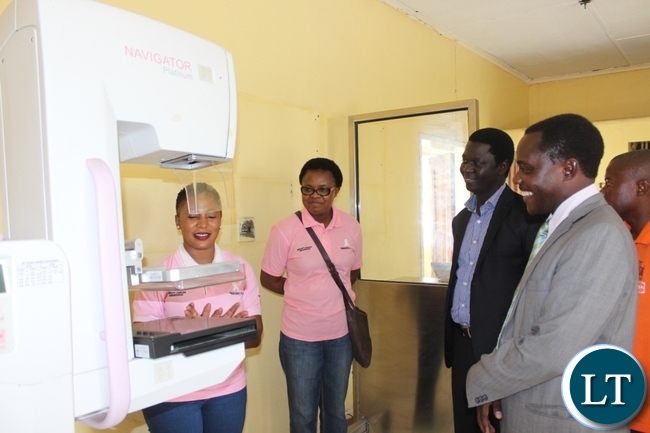 Lewanika General Hospital Radiographer Technologist Angelica Mwaba (l) demonstrates on a Mammography Machine as Western Province Assistant Secretary Sineva Kambenja (r), Provincial Medical Officer Dr. Andrew Silumesii (2nd r) and Hospital Medical Superintendent Dr. Mapani Mutanga (2nd l) observe during the Breast Cancer Awareness Month Commemoration at Lewanika General Hospital in Mongu