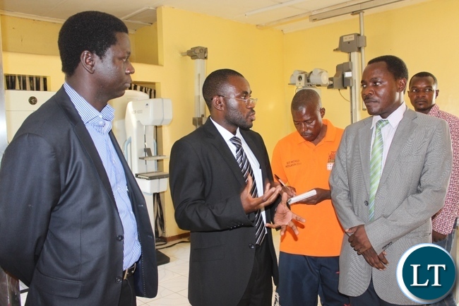 Lewanika General Hospital Mammography Department Dr. Kambinde Likambo (c) explains to Western Province Assistant Secretary Sineva Kambenja (r) as Provincial Medical Officer Dr. Andrew Silumesii (l) looks on during the Breast Cancer Awareness Month Commemoration at Lewanika General Hospital in Mongu