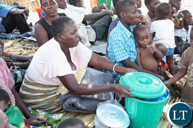 A woman (c) of Imuba Village gathers her relief support from DMMU as a victim of a firestorm which burnt the entire village to ashes in Lower Katongo area in Mongu. A woman (c) of Imuba Village gathers her relief support from DMMU as a victim of a firestorm which burnt the entire village to ashes in Lower Katongo area in Mongu.