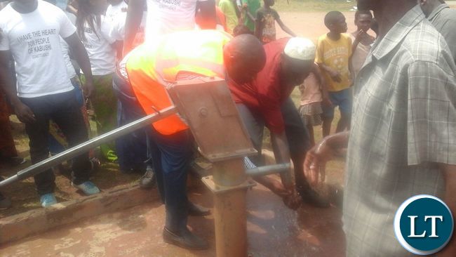 Bowman Lusambo watching his hands after water started flowing after three years since the borehole broke down