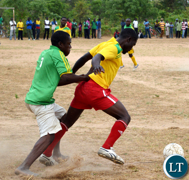 Limpo Siachaba (in green jersey) of Mochipapa Research football club fight for the ball with Moses Muleya of Sikalongo football club in which the two teams drew 1-1 at the weekend. Insert, Patriotic Front Member of the Central Committee Syacheye Madyenkuku (holding balls) with Choma central Constituency party secretary Joel Kamoko (left) and Constituency chairperson Timothy Siakaziba (immediate right) about to present footballs to the winner of the Sikalongo ward tournament