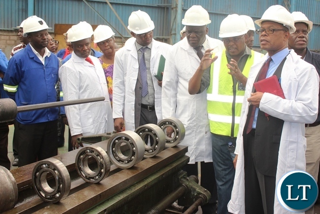 Transport and Communications Minister Kapembwa Simbao (right) listening to Zambia Railways Director Rolling Stock Webster Mtambo during the tour of the workshop in Kabwe
