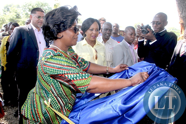 First Lady Esther Lungu and Steven Din, KCM Chief Executive Officer cuts a ribbon during the commissioning of Hellen Bridge Constructed by KCM in Shimulala area in Chingola on Tuesday, December 8,2015. The First Lady was in Chingola where she checked and witnessed various projects that are being undertaken by various stakeholders and those that are undertaken by Konkola Copper Mine (KCM) under Corporate Social responsibility -Picture by THOMAS NSAMA