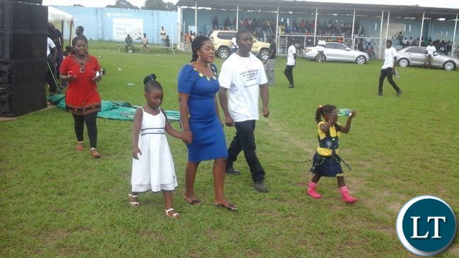 Mrs Lusambo and daughter Sibongile walking over to the stage for her remarks