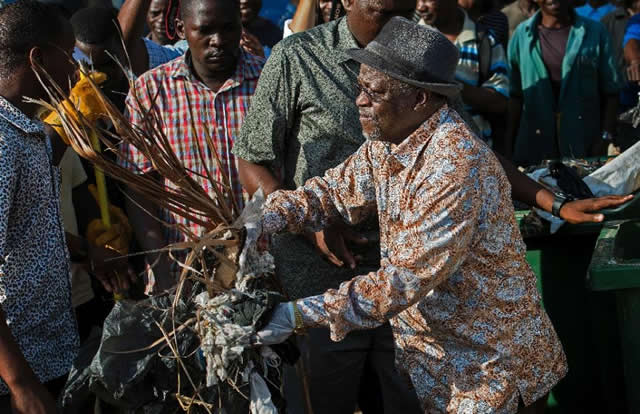 Tanzanian President John Magufuli joins a clean-up event outside the State House in Dar es Salaam on December 9, 2015 Magufuli cancelled Independence Day celebrations and ordered a national day of clean-up instead. (AFP Photo/Daniel Hayduk)